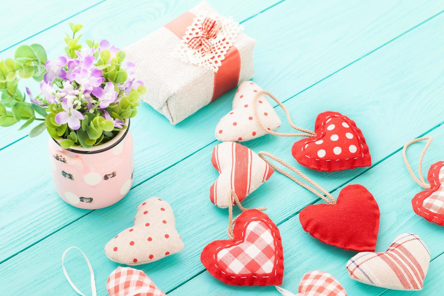 Hearts and flowers on blue wooden background. Selective focus photo