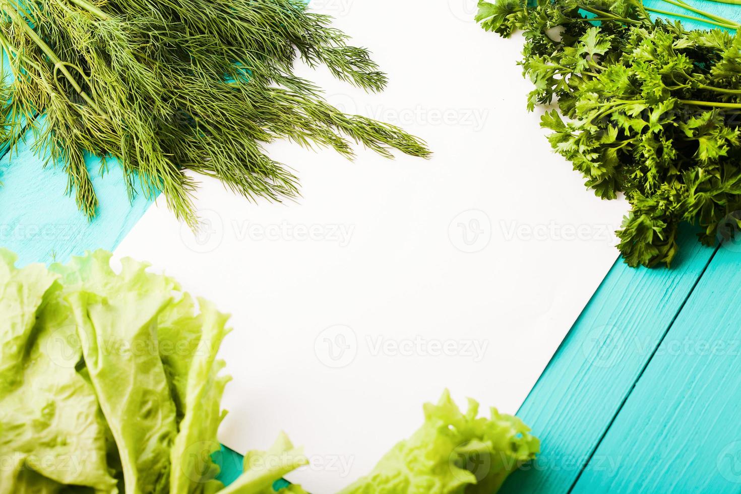 Parsley and recipe paper on blue wooden kitchen table. Top view photo