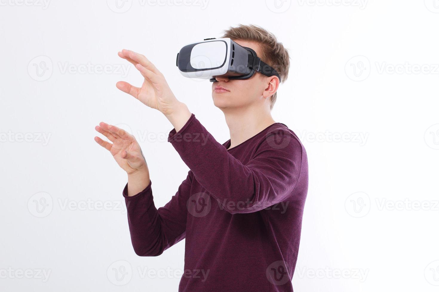 Excited young man in a VR headset, glasses. Virtual reality isolated on white background. Copy space and mock up photo