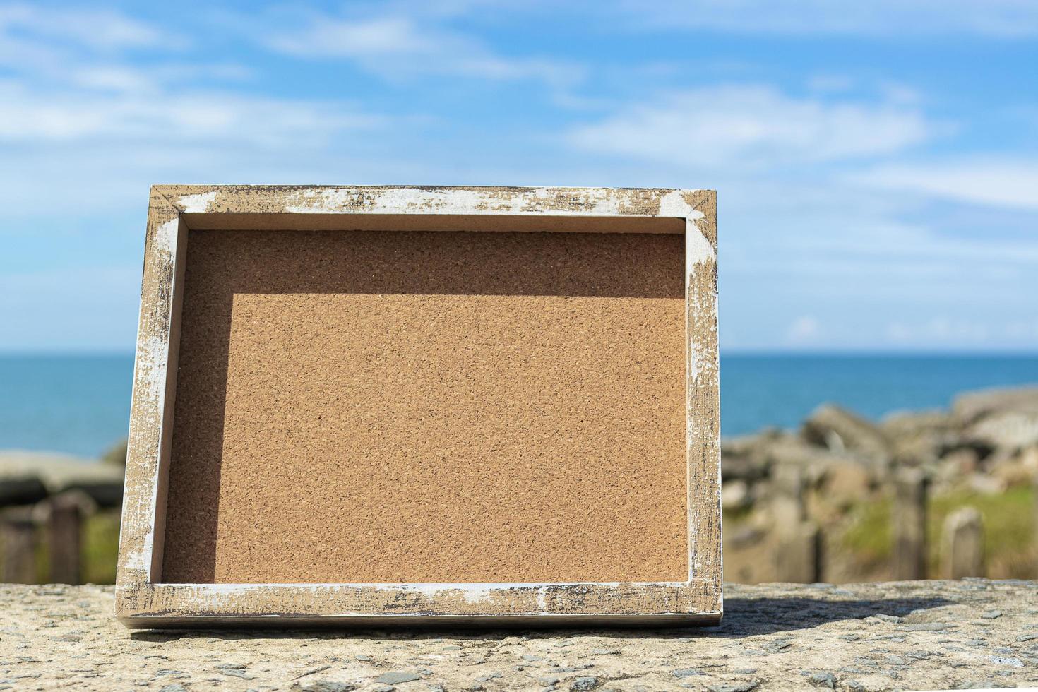 Wooden frame with blurred background of ocean and blue sky photo