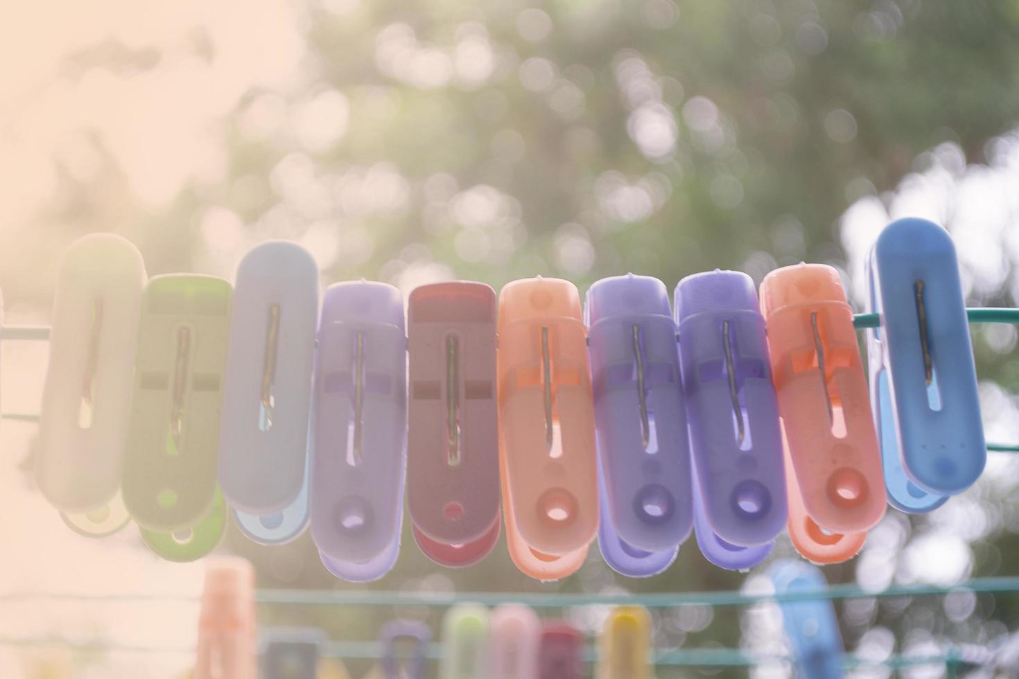 An image of very colorful clothes pegs on a clothesline photo
