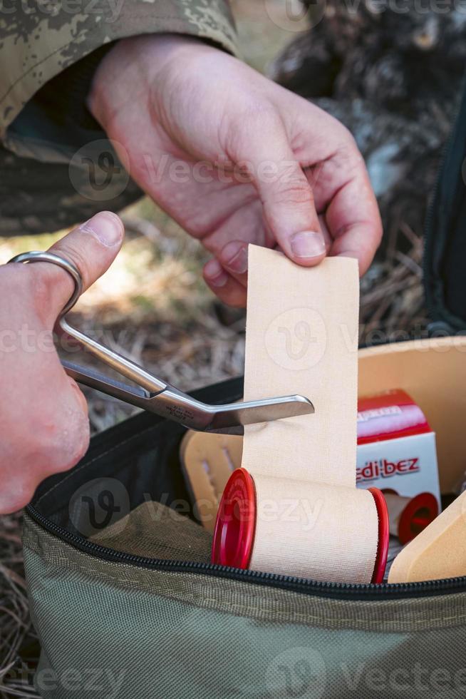 Military army first aid kit. Camouflaged soldier medic. photo