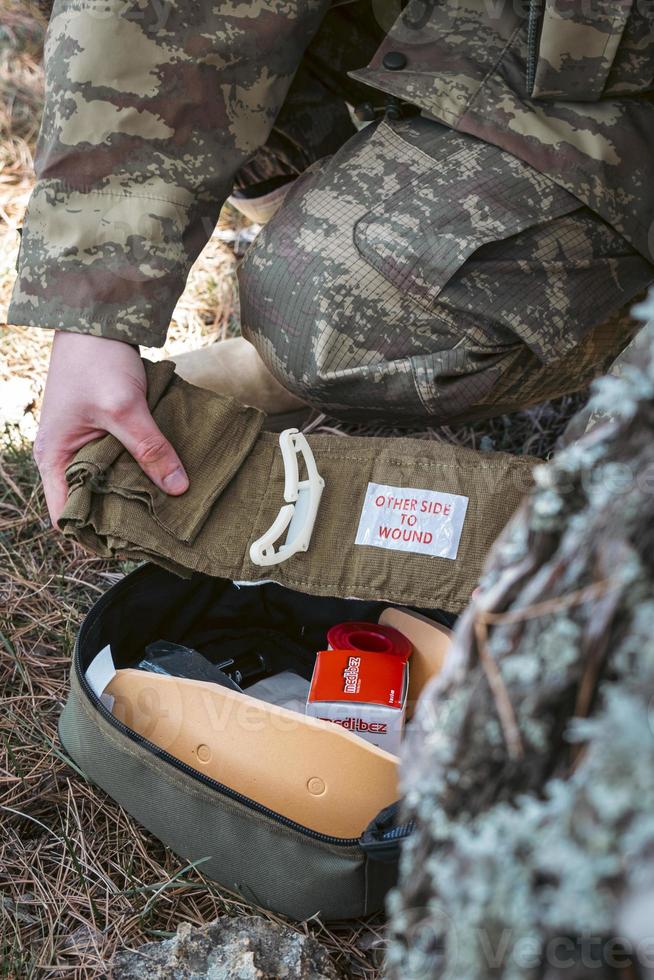 Military army first aid kit. Camouflaged soldier medic. photo