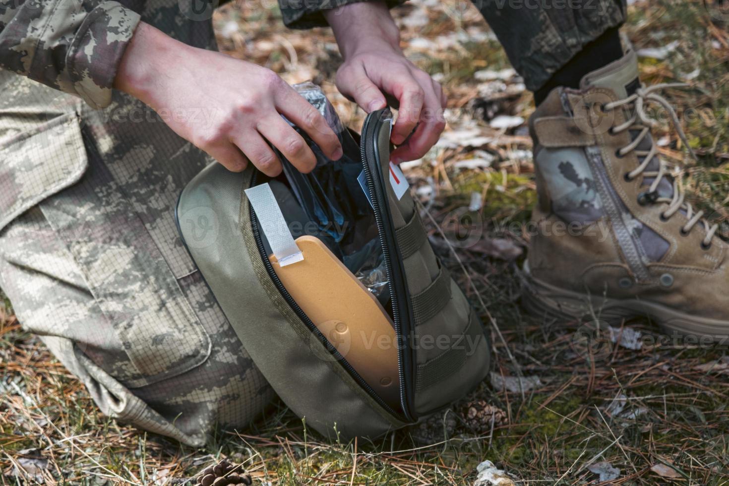 Military army first aid kit. Camouflaged soldier medic. photo