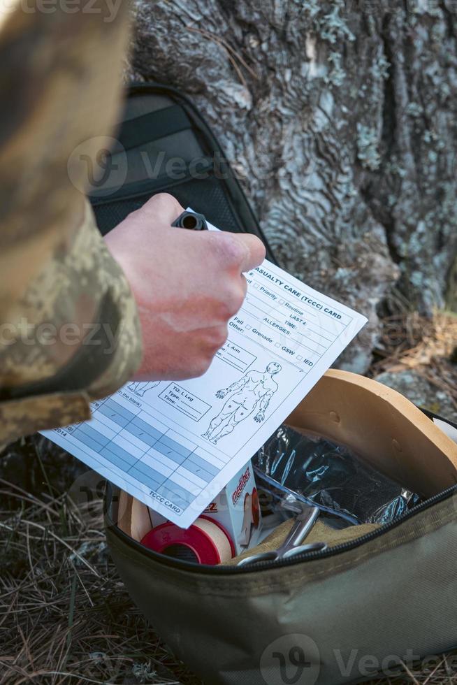 Military army first aid kit. Camouflaged soldier medic. photo