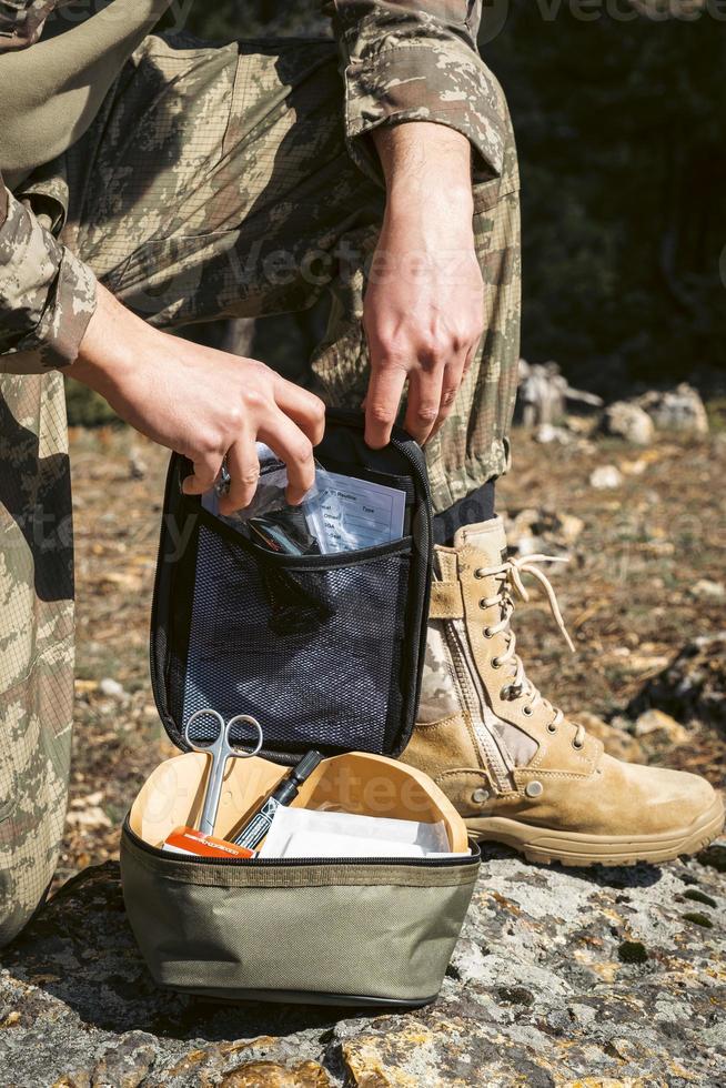 Military army first aid kit. Camouflaged soldier medic. photo