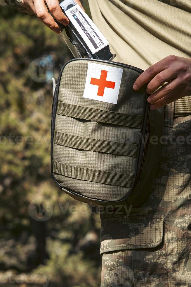 Military army first aid kit. Camouflaged soldier medic. photo