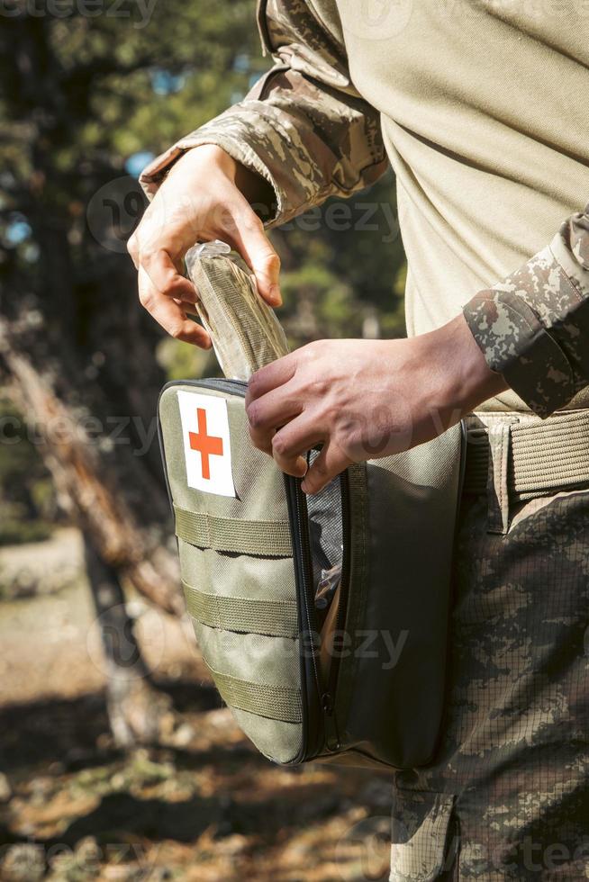 Military army first aid kit. Camouflaged soldier medic. photo