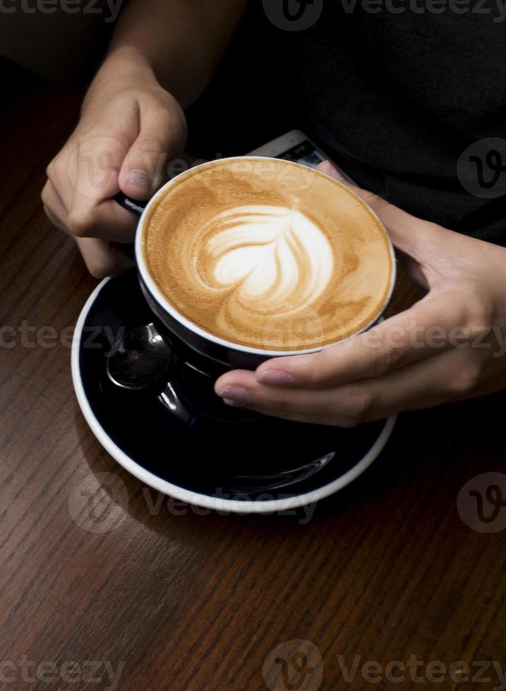 Coffee latte in her hand. Dark background photo