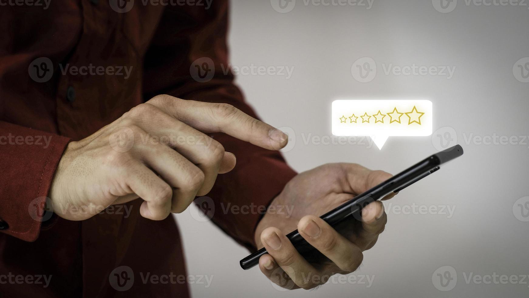 Close up on Customer Man Hand press on smartphone screen with gold five star comment icon and excellent press level for best rating in business idea service review. photo