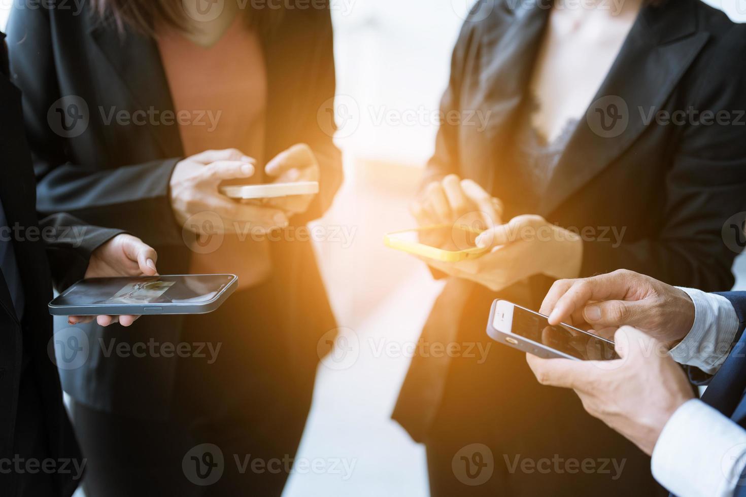 Group of young business people standing and using smartphone together concepts communication. photo