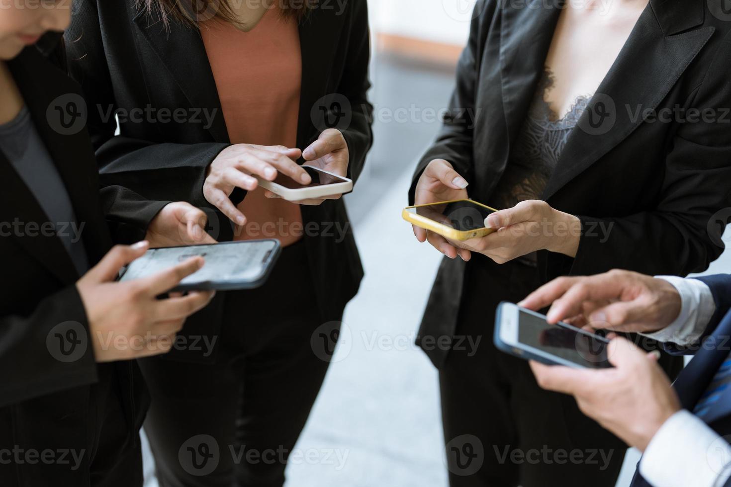 Group of young business people standing and using smartphone together concepts communication. photo