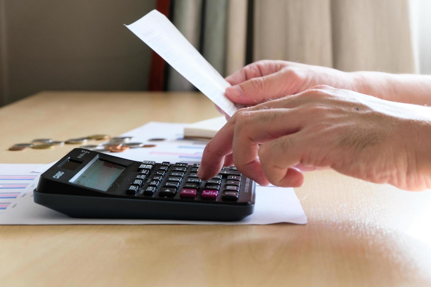 Selective focus of Men using calculator, holding invoice and check his salary for plan personal expense budget. Individual balance sheet for saving and payment control. Financial and economy concept. photo