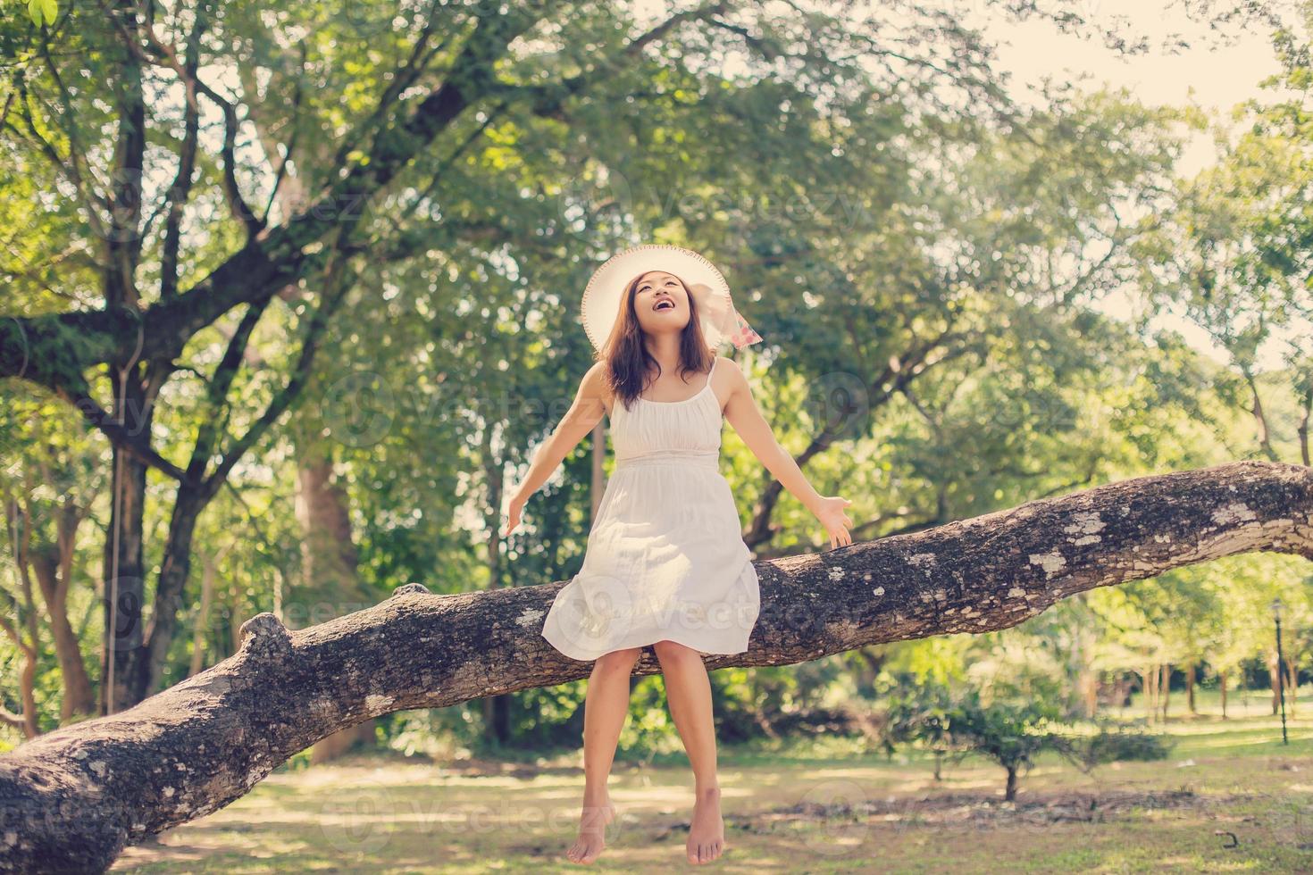 Young teen girl sitting on tree photo