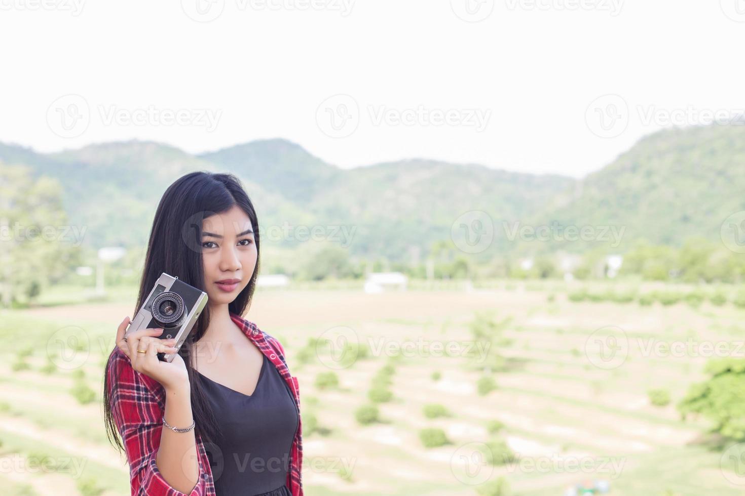 Young hipster woman photographer holding a vintage camera. photo