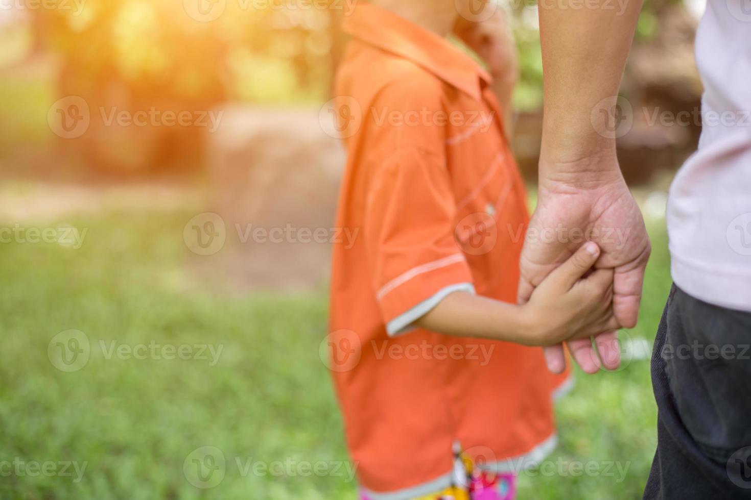 a the parent holds the hand of a small child photo