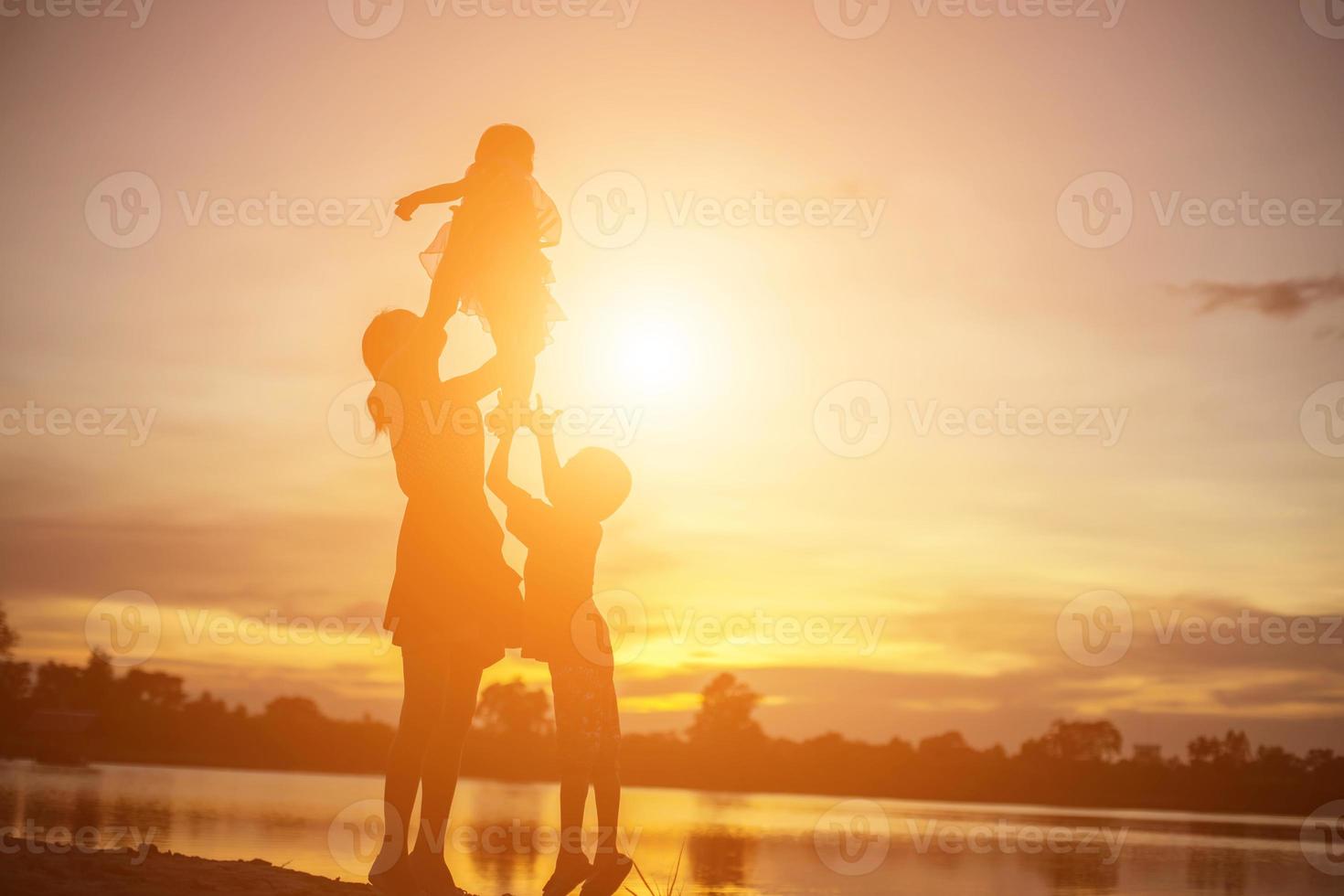 madre animó a su hijo al aire libre al atardecer, concepto de silueta foto