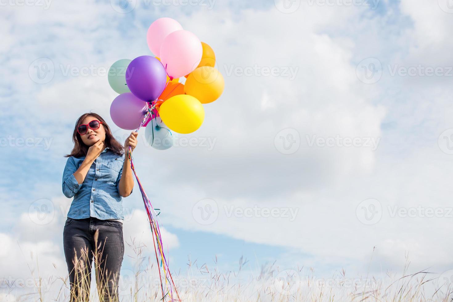 Beautiful Girl jumping with balloons on the beach photo