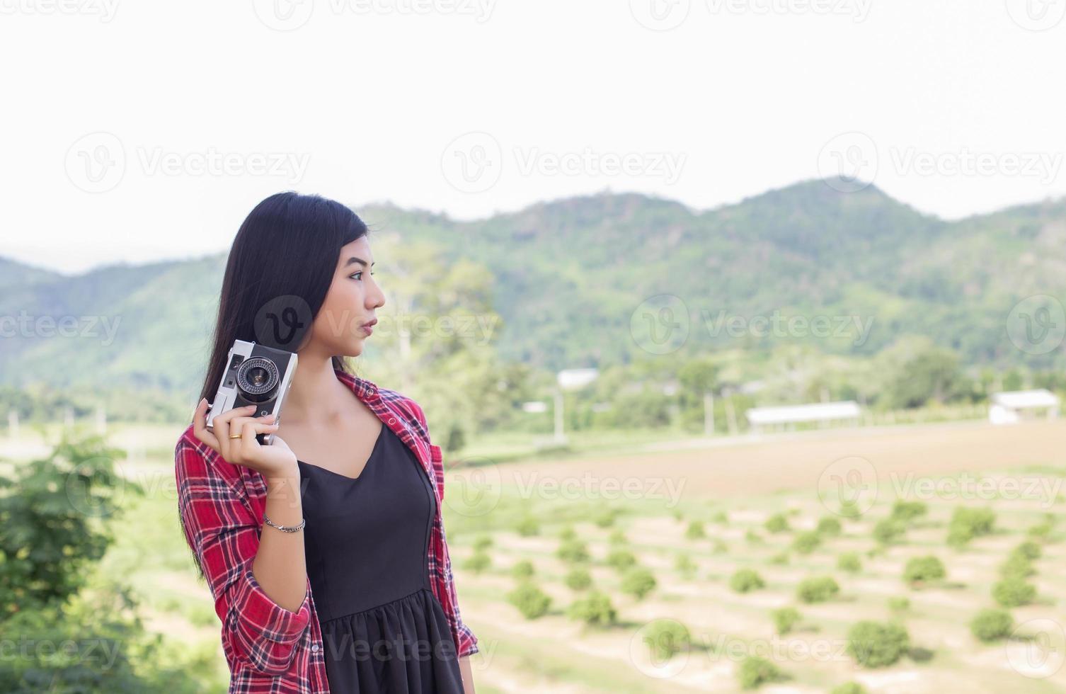 Young hipster woman photographer holding a vintage camera. photo