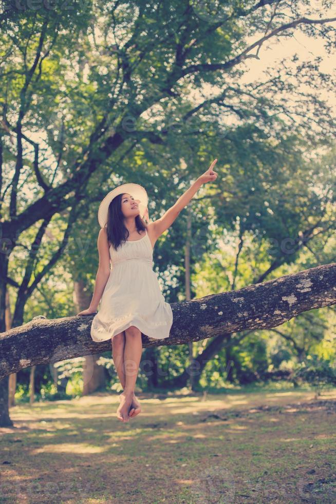 joven adolescente sentada en un árbol foto