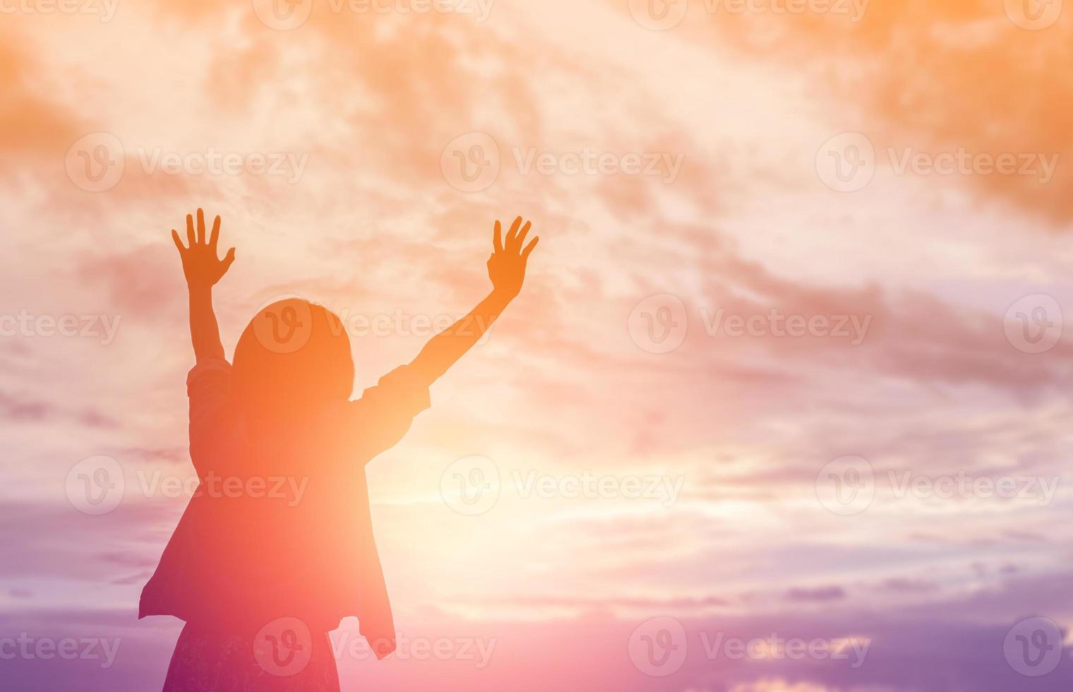 silueta de mujer rezando sobre un hermoso cielo de fondo foto