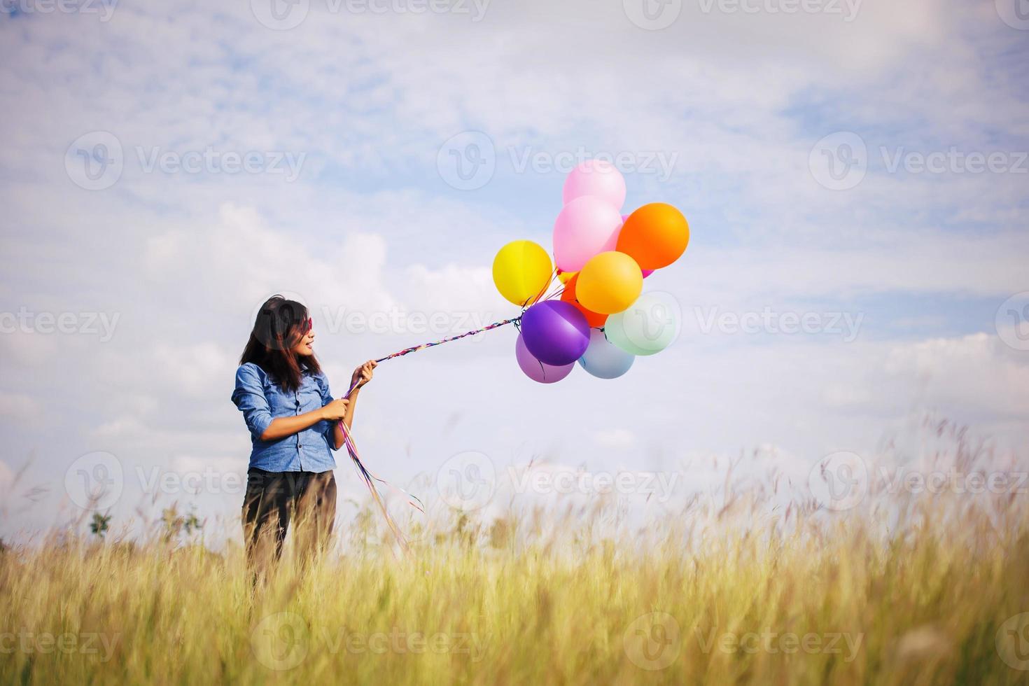 Beautiful Girl jumping with balloons on the beach photo