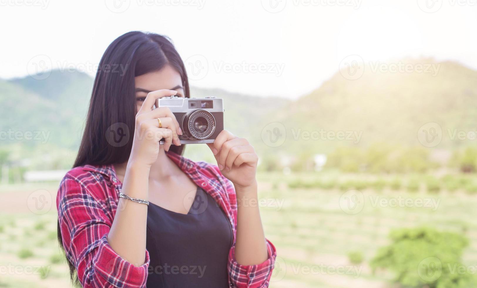 Young hipster woman photographer holding a vintage camera. photo