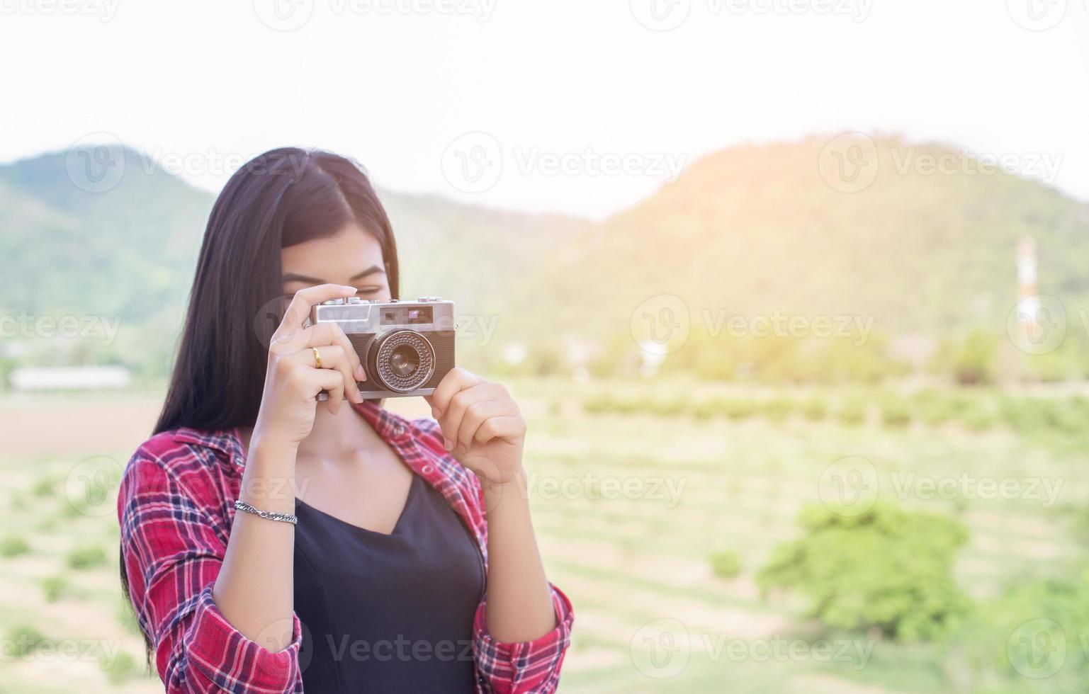 Young hipster woman photographer holding a vintage camera. photo