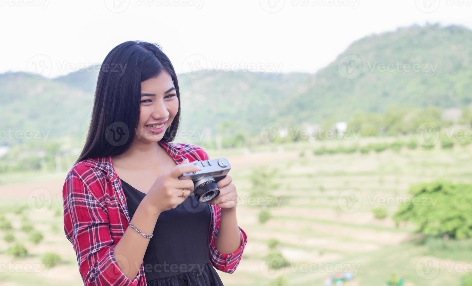 Young hipster woman photographer holding a vintage camera. photo
