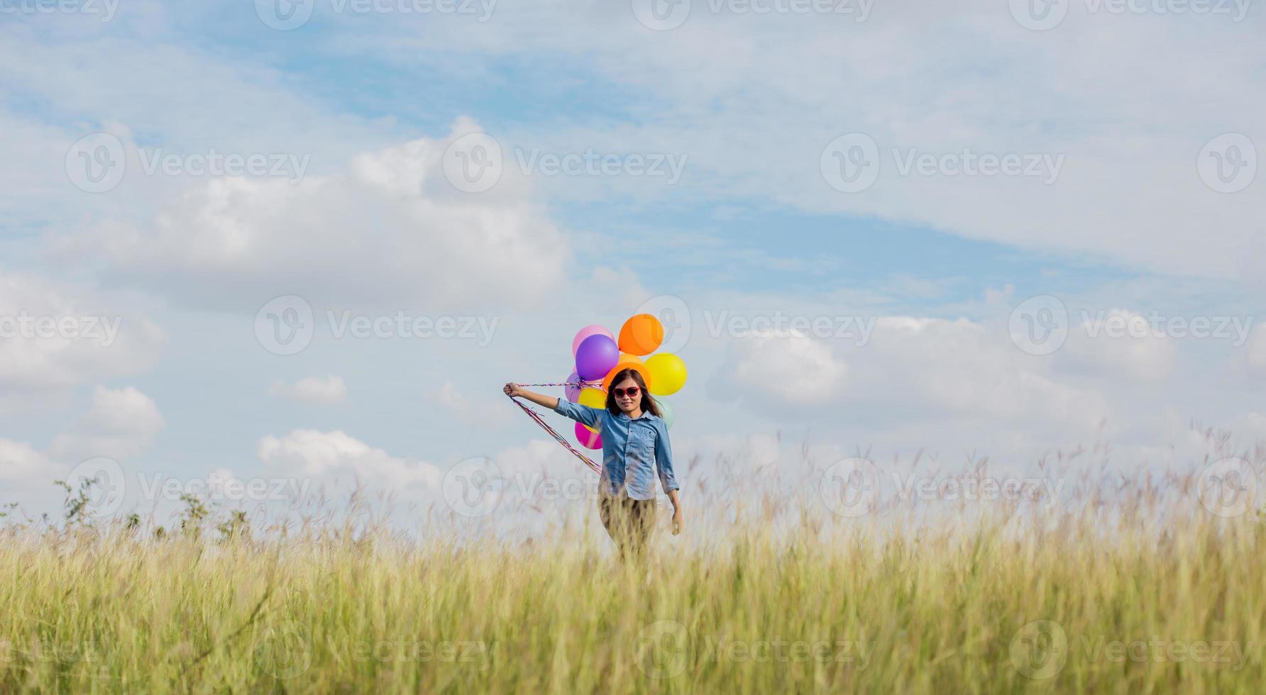 Beautiful Girl jumping with balloons on the beach photo