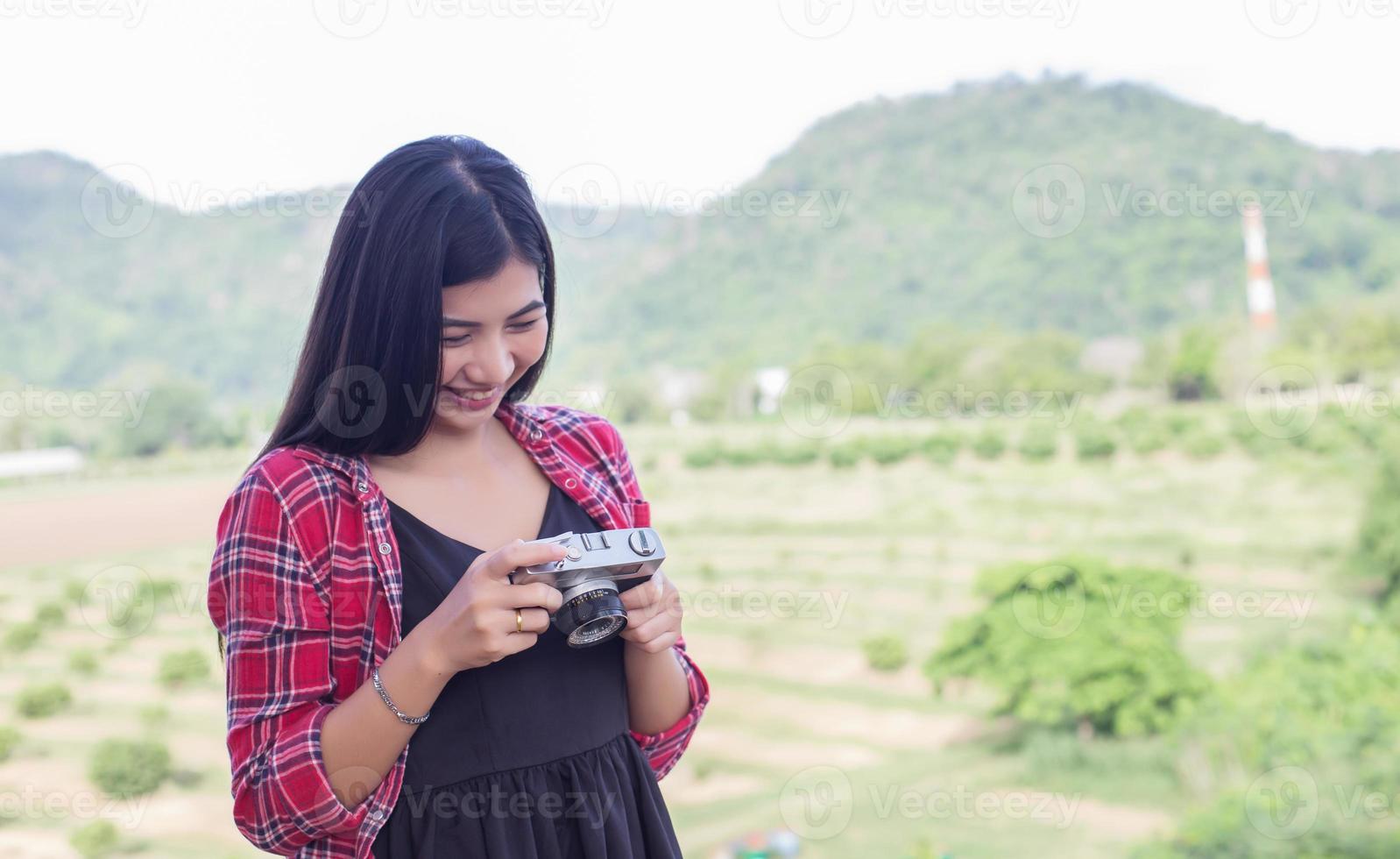 Young hipster woman photographer holding a vintage camera. photo