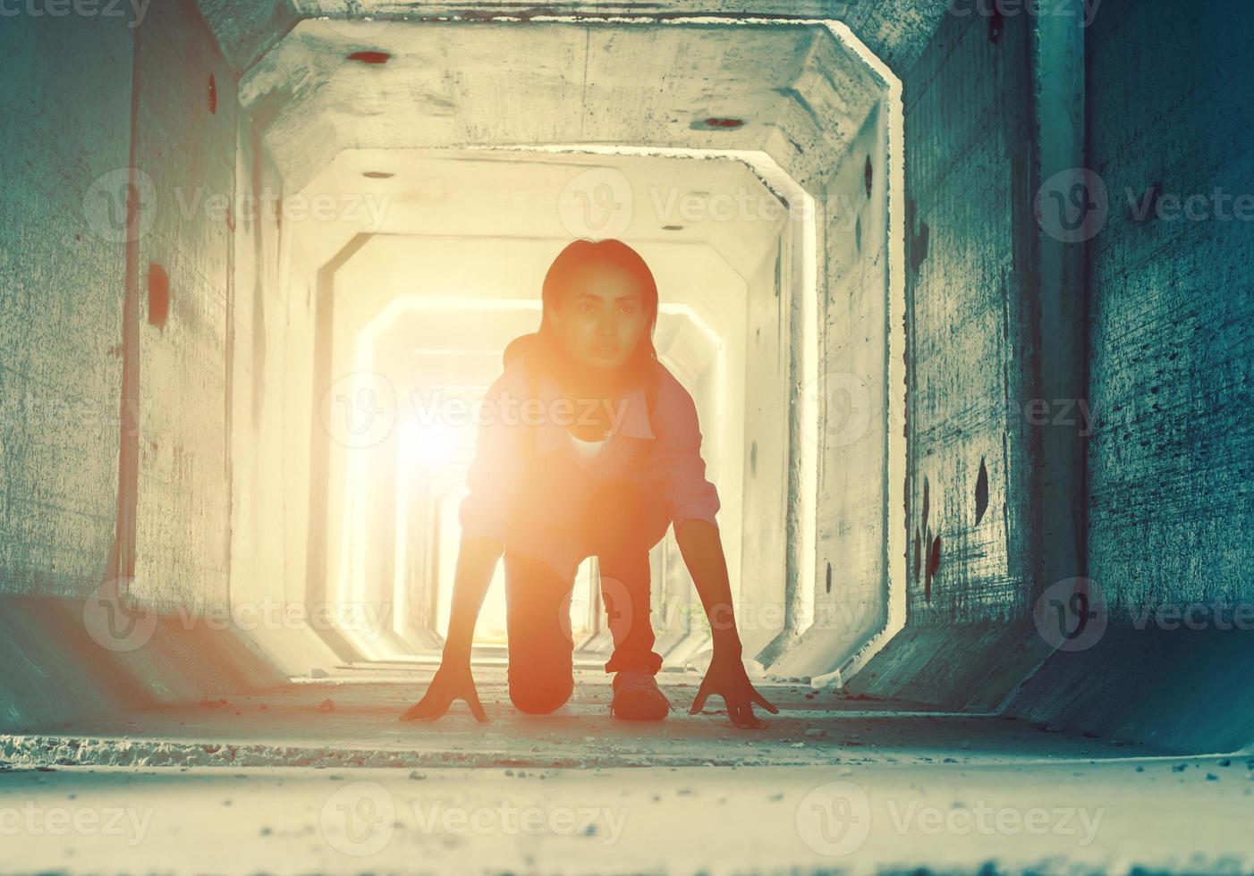 Backlight of a teenager depressed sitting inside a dirty tunnel photo