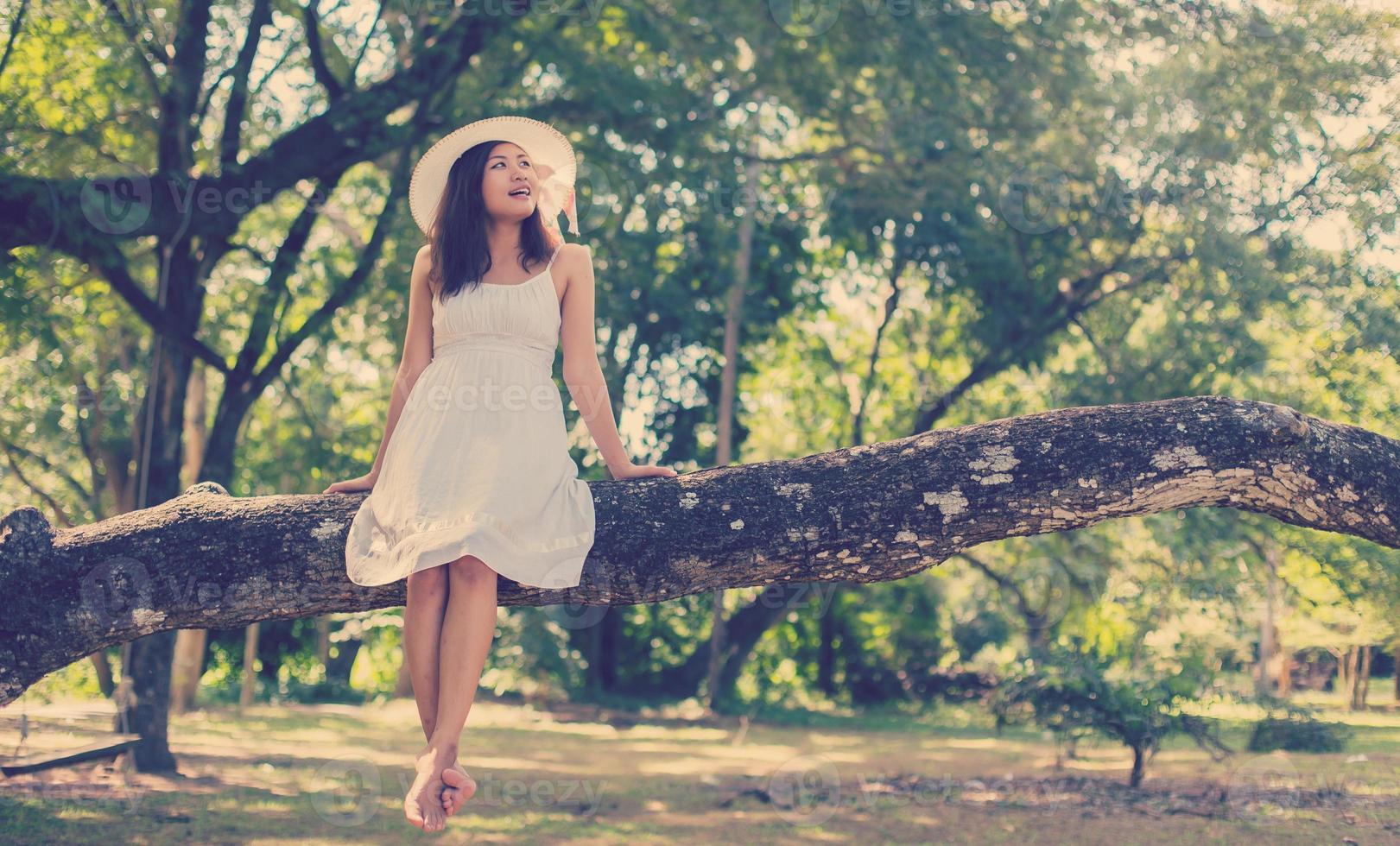 Young teen girl sitting on tree photo