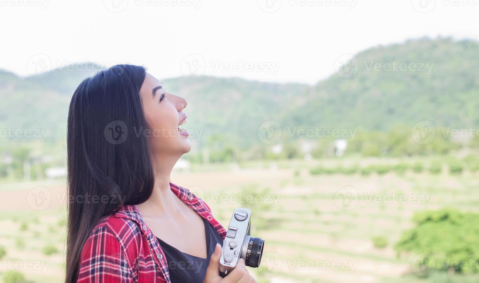 joven fotógrafa hipster sosteniendo una cámara vintage. foto