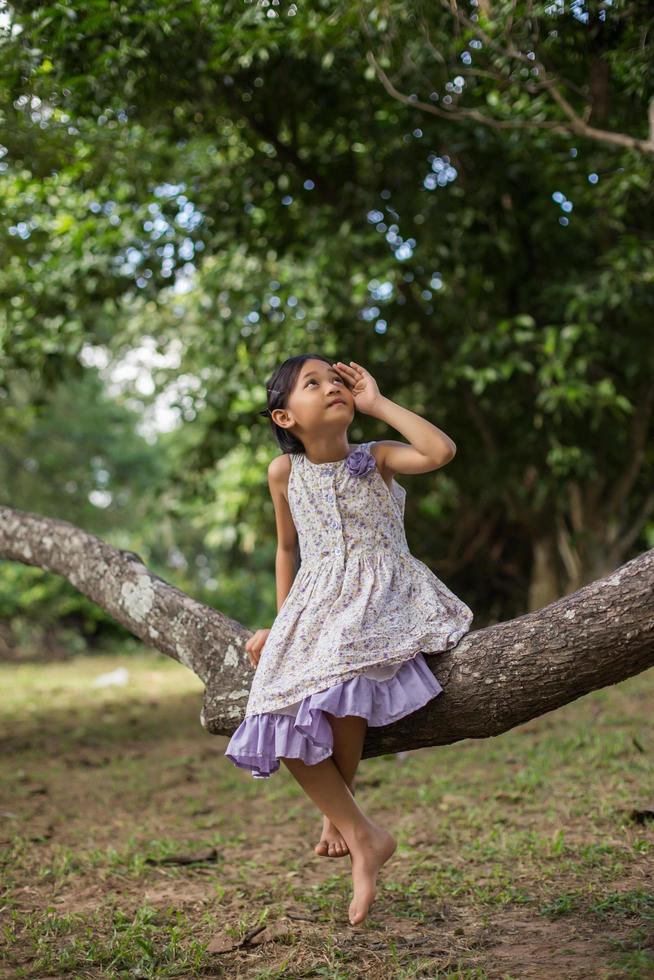 Little cute asian girl standing among the purple flower field sunshine day. Freedom enjoying with nature. photo