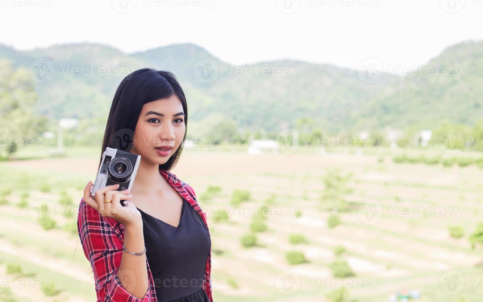 Young hipster woman photographer holding a vintage camera. photo