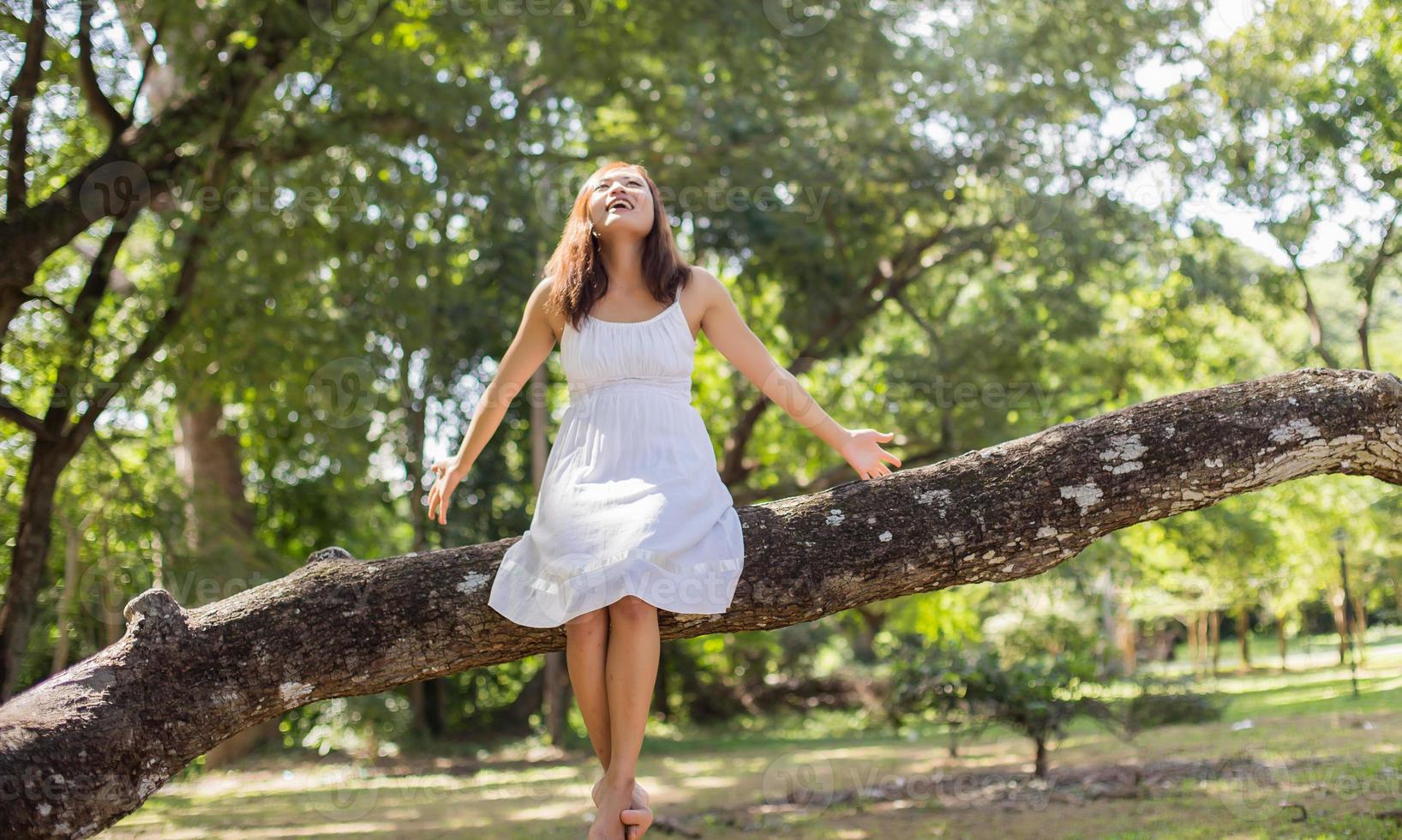 Young teen girl sitting on tree photo
