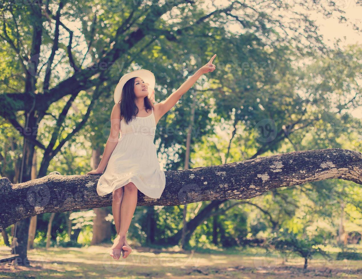 Young teen girl sitting on tree photo