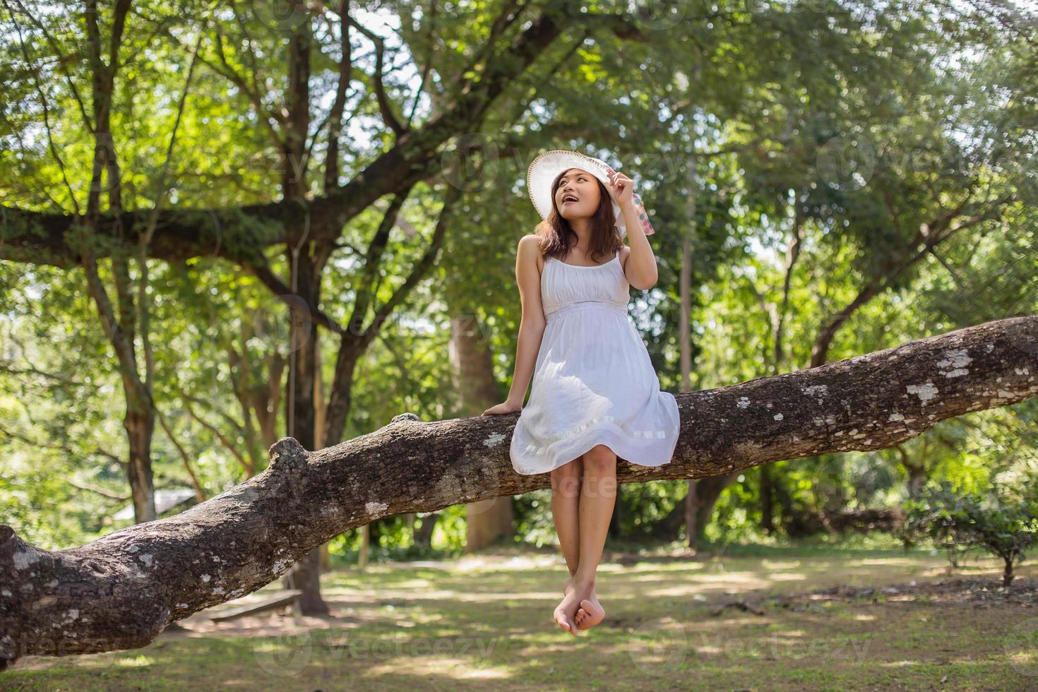 Young teen girl sitting on tree photo