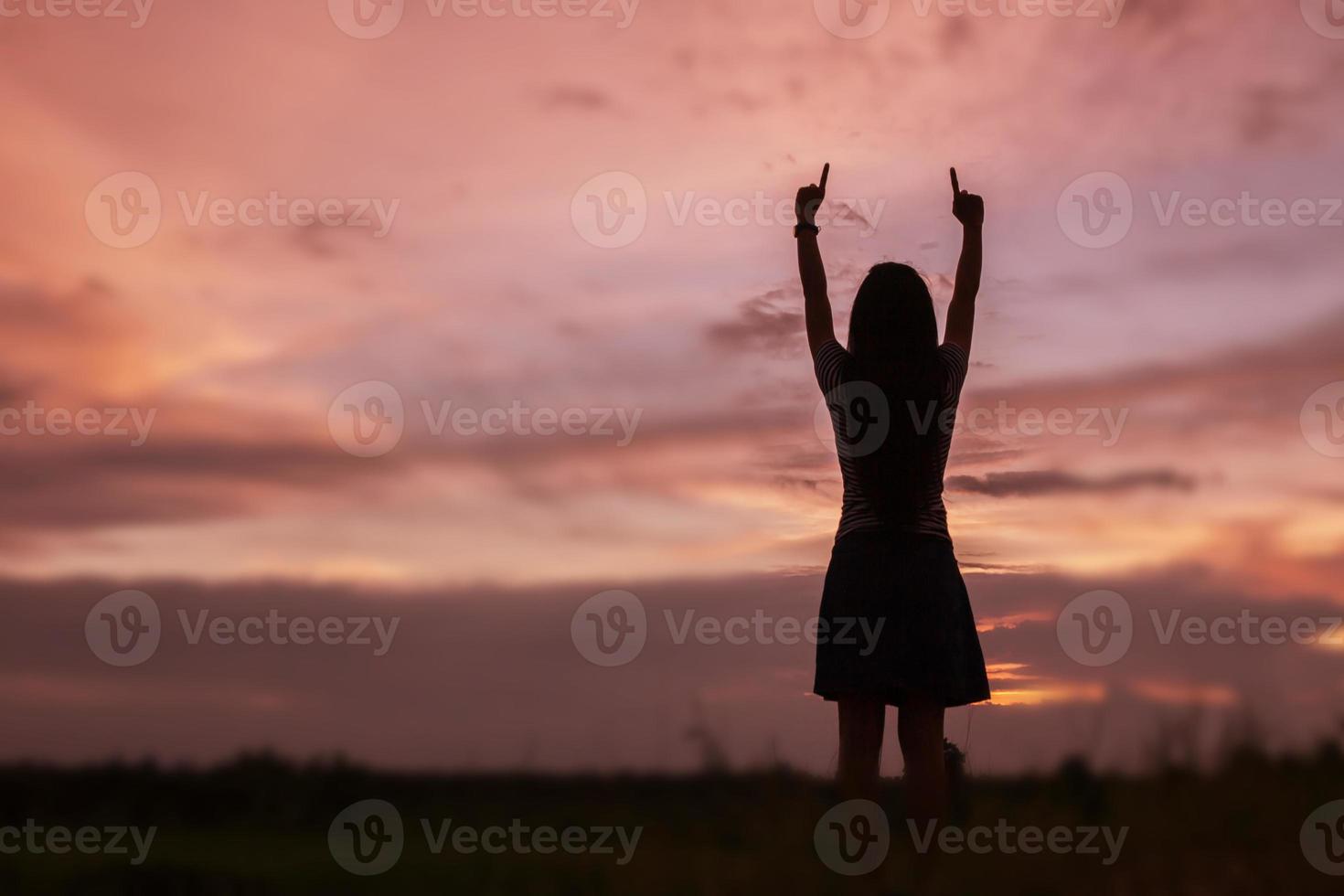 Silhouette of woman praying over beautiful sky background photo