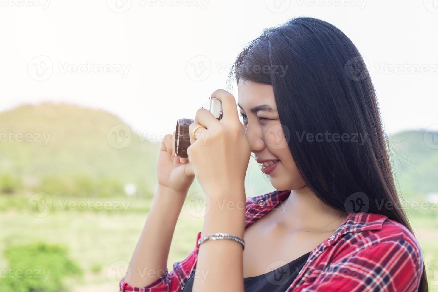 Young hipster woman photographer holding a vintage camera. photo