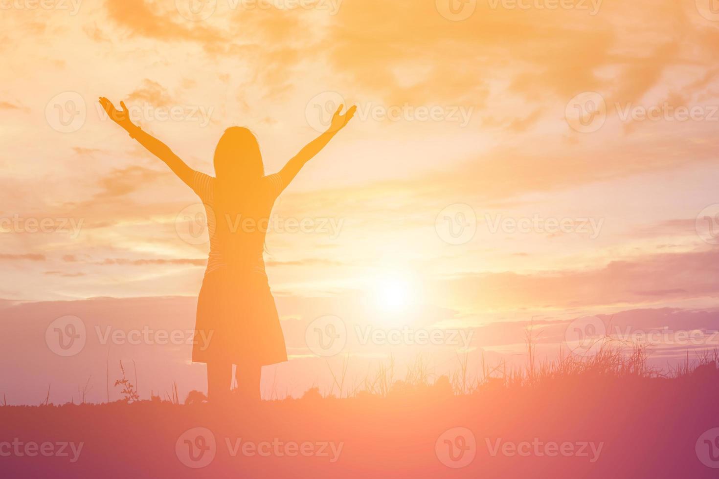 Silhouette of woman praying over beautiful sky background photo