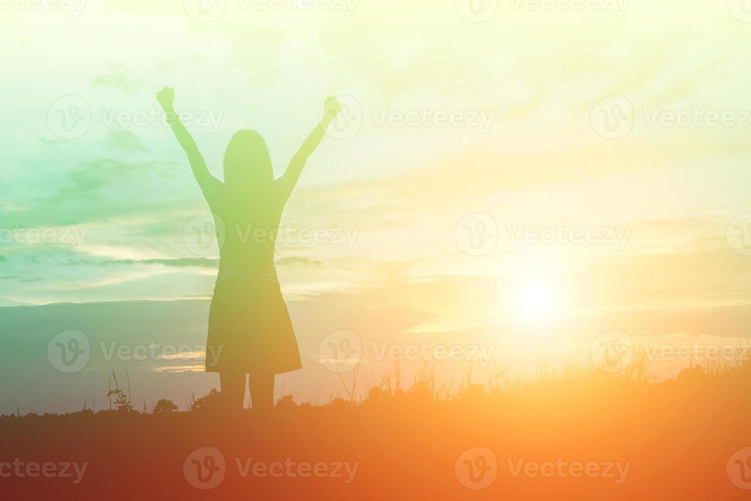 Silhouette of woman praying over beautiful sky background photo