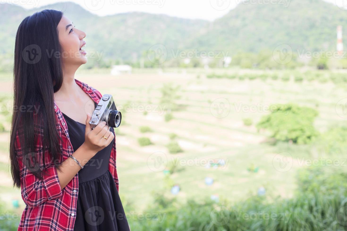 Young hipster woman photographer holding a vintage camera. photo