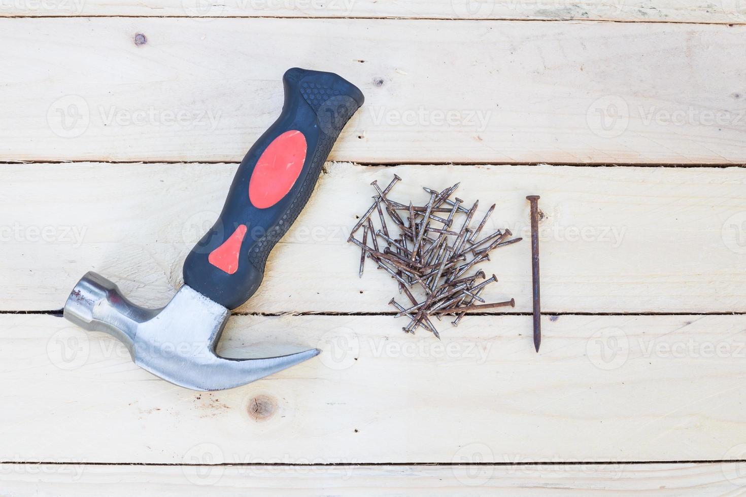 Hammer and rusty nails on white wooden background photo