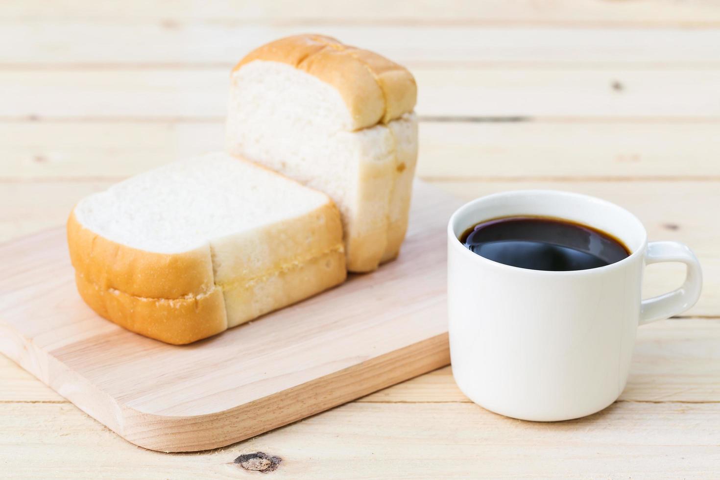 taza de café y pan en el piso de madera foto