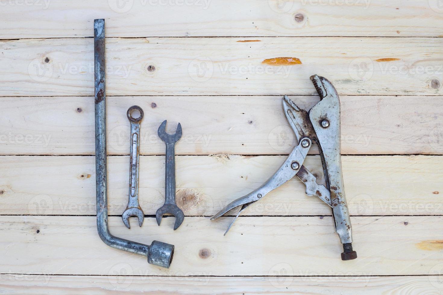 Rusty wrench and locking pliers on white wood photo