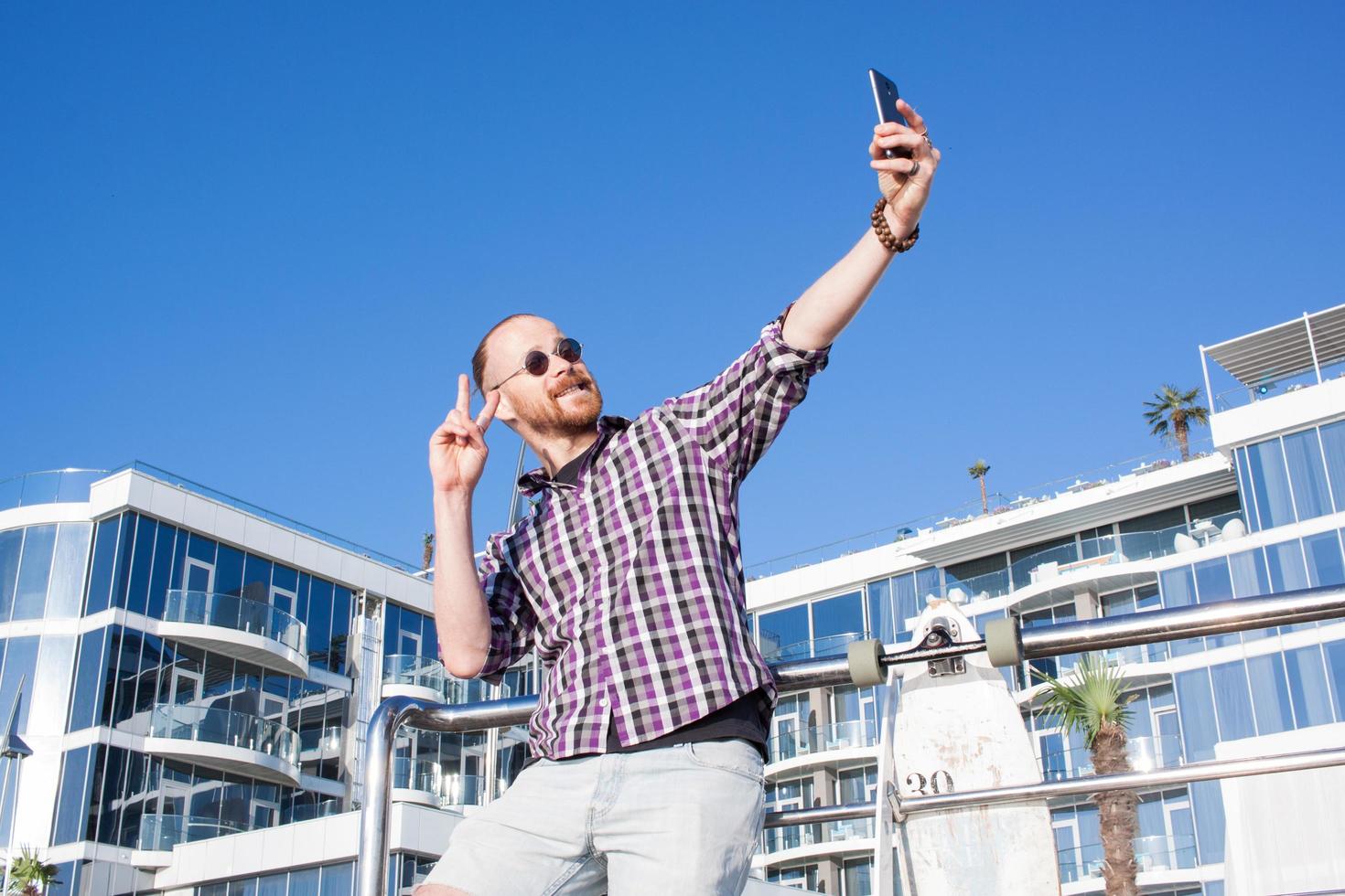 joven barbudo se hace selfie por teléfono foto