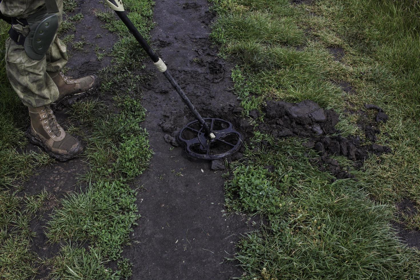 Soldier using a metal detector in fields photo