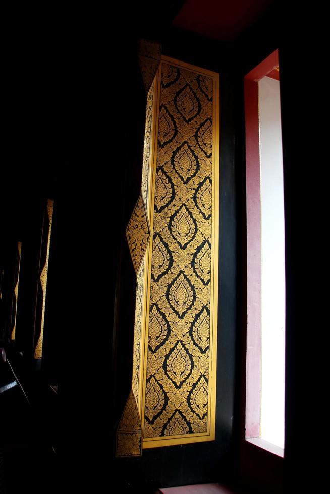 Ancient golden Thai native painting on window opening of church in wat Suwandararam temple, Ayutthaya province, Thailand. This temple was builded more than 200 years ago. photo